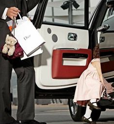 a man in a tuxedo getting out of a car with a teddy bear