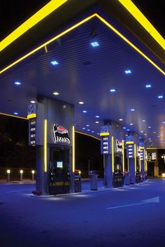 an empty gas station at night with neon lights