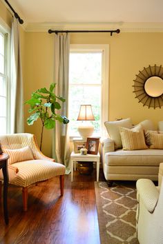 a living room filled with furniture and a large mirror on the wall above the couch