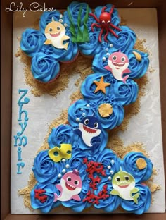 a birthday cake decorated with blue frosting and various sea animals on top of it