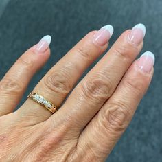 a woman's hand with a gold ring on it and two diamonds in the middle