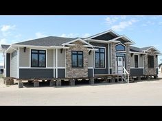 two story house being built on the side of a road in front of a blue sky