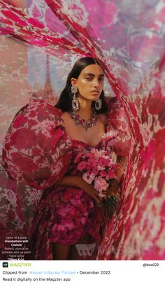 a woman in a pink dress with flowers on her chest and arms around her body