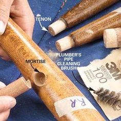 a close up of a person holding a wooden pipe with other items surrounding it on a table