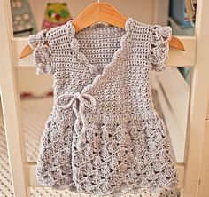 a crocheted dress hanging on a clothes rack in a child's room