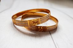 "A pair of nice gold tone metal bracelets. They have a nice weight to them and have no makers marks. The bracelets measure 0.4\" wide and 2.5\" across.  All jewellery is shipped in a gift box. PROCESSING AND SHIPPING TIMES: Please check my shop policies for latest info on shipping https://www.etsy.com/uk/shop/TrudysStoreClothing/policy?ref=shopinfo_policies_leftnav Thanks for looking! WEB: www.trudysstore.com FACEBOOK: www.facebook.com/TrudyStore INSTAGRAM: @trudys_store TWITTER: @silkepants PINTEREST: www.pinterest.com/silkepants" Etched Gold Bangle Bracelet For Wedding, Elegant Gold Band Bangle, Gold-plated Bracelet With Intricate Design, Gold Etched Bracelet For Anniversary, Wedding Gold Brass Bracelets, Gold Plated Bracelet With Intricate Design, Gold Engraved Bangle For Anniversary, Ceremonial Gold Engraved Bangle, Gold Brass Bangle With Intricate Design