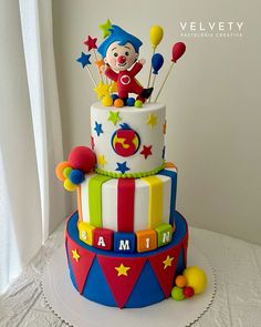 a multi - tiered birthday cake decorated with clowns and stars