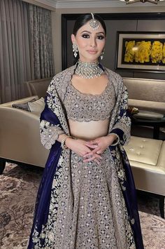 a woman standing in a room wearing a bridal gown and jewelry on her head