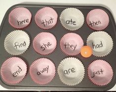 there are cupcakes with words in them on the baking tray and an orange ball