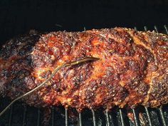 a large piece of meat is cooking on the grill