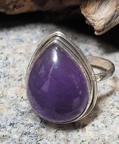 This is a sterling silver and garnet ring. The stone is 3/4 of an inch tall. Amethyst is said to act as protection and to disperse negative energy. This is a new, unworn, vintage store stock ring. It comes in a jewelry box for gifting. Silver Teardrop Rings With Spiritual Style, Silver Spiritual Teardrop Ring, Spiritual Silver Teardrop Ring, Spiritual Teardrop Gemstone Rings, Spiritual Teardrop Rings For Anniversary, Mystical Amethyst Ring In Sterling Silver, Mystical Sterling Silver Rings In Purple, Mystical Sterling Silver Amethyst Ring, Mystical Sterling Silver Purple Rings