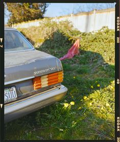 an old car is parked in the grass