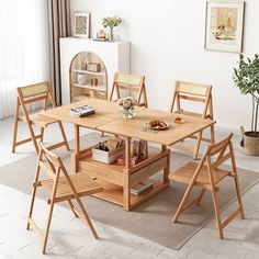 a wooden table with four chairs and a shelf on the floor in front of it