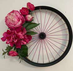 pink flowers are placed on the rim of a bicycle wheel as if it were made out of spokes