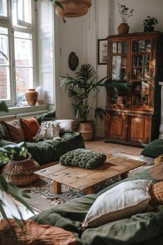 a living room filled with lots of green couches and pillows on top of a wooden table