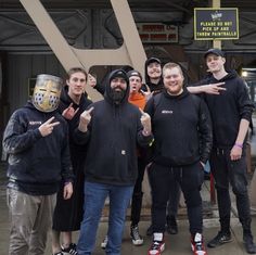 a group of men standing next to each other in front of a building with the letter y on it