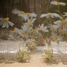 an outdoor wedding setup with white chairs and flowers