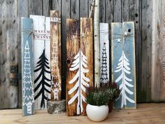 some wooden boards with trees painted on them and a potted plant in the middle