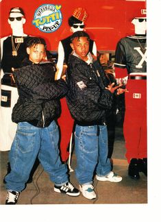 two young boys standing next to each other in front of costume mannequins