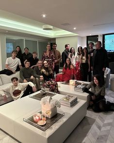 a group of people standing and sitting around a living room