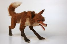 a toy fox with its mouth open on a white background