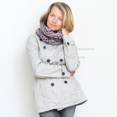 a woman wearing a coat and scarf posing for the camera