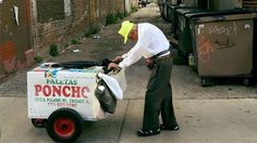 a man is pushing a cart down the street