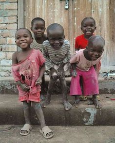 five children are standing on the steps in front of a door with mud all over them