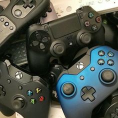 a pile of video game controllers sitting next to each other on top of a table