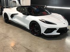 a white sports car parked in a garage