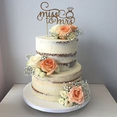 there is a wedding cake with flowers on the top and a sign that says mr and mrs