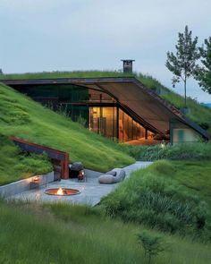 an outdoor fire pit in the middle of a grassy area with grass growing on top