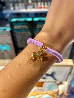 a person's arm with a bracelet on it and a small gold dog charm