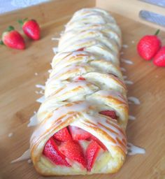 strawberry danish braid on a cutting board with strawberries