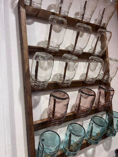 an old ladder is filled with glasses on the wall