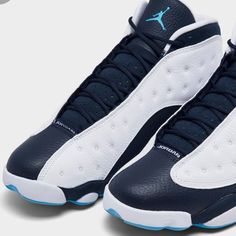 The Air Jordan 13 Retro ‘Obsidian’ Updates The Vintage Mid-Top With A Familiar Color Scheme, One That Combines Stitched Tumbled White Leather With Contrasting Navy Blue Paneling. A Jumpman Icon In Dark Powder Blue Is Embroidered Atop The Tongue, While The 13’s Holographic Cat Eye Decorates The Lateral Ankle. Underfoot, The Distinctive Panther Paw Outsole Features Herringbone Rubber Traction Pods And A Carbon Fiber Shank Plate For Improved Stability. Navy Basketball Shoes With Boost Midsole, Navy Leather High-top Basketball Shoes, Navy Leather Basketball Shoes With Round Toe, Navy Leather Basketball Shoes With Cushioned Footbed, Blue Paneling, Jordan Obsidian, Jordan Retro 2, Jordan 1 Mid Chicago, Jordan Retro 10