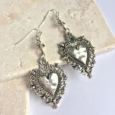 These Long Silver Sacred Heart Earrings Make A Statement. The Dark Patina In The Small Details Of The Charms Adds To The Lovely Handmade Feel. Silver Plated Ear Wires & Charms. Approx. Size: 211/16"L, 11/8"W New, Handmade By: Jpeace Designs *See My Other Listings In This Sacred Heart Collection* Religious, Rockabilly, Dia De Los Muertos, Day Of The Dead, Punk, Rock N Roll, Edgy Jewelry, Lady Biker, Skull, Virgin De Guadalupe, Mexico, Western, Sundance, Artsy, Vintage Antique Style Silver Bohemian Heart Earrings For Valentine's Day, Silver Bohemian Earrings For Valentine's Day, Sacred Heart Earrings, Sacred Heart Jewelry, Artsy Earrings, Edgy Jewelry, Lady Biker, Cross Earrings, Small Details