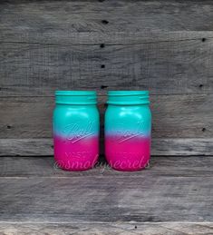 two blue and pink mason jars sitting side by side