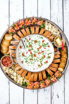 a platter filled with bread, crackers and dip