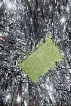 a green piece of cloth sitting in the middle of some tin foils and mirrors