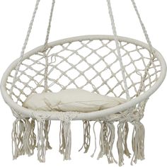 a white hanging chair with tassels and a pillow on it's back