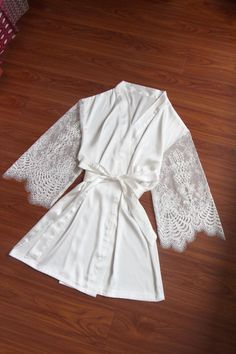 This robe is very special and beautiful, with sheer lace sleeves Free size for US2-12 Length: above knee length, about 33-34 inches length fabric: satin cream white color Sleeves: Sheer lace sleeve, long Sleeve Please know the robe is a bit see through for white fabrics, and sleeves part is sheer lace fabric, avoid dark color underwear, and please wear a slip dress underneath if needed Thank you so much Lace Wedding Night Robe With Lace Sleeves, Elegant Long Sleeve Robe For Bridal Shower, White Long Sleeve Robe For Bridal Shower, Cream Satin Robe For Wedding Night, Elegant Wedding Robe With Lace Cuffs, White Long-sleeved Robe For Brides, White Long Sleeve Bride Robe, Fitted Robe With Lace Sleeves For Wedding Night, White Lace Trim Robe For Wedding Night