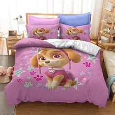 a pink bed with a cartoon dog on the cover and pillow cases in front of it