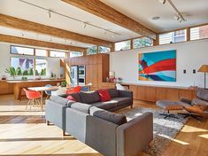 a living room filled with lots of furniture and large windows above it's ceiling