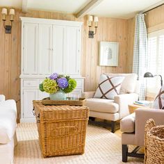 a living room filled with lots of furniture and flowers on top of a coffee table