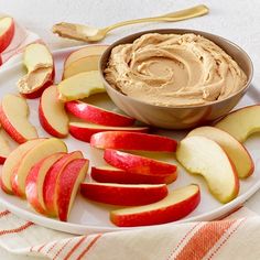 apples and peanut butter on a plate with spoons