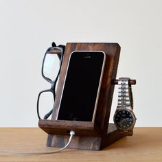 a cell phone and glasses on a wooden stand