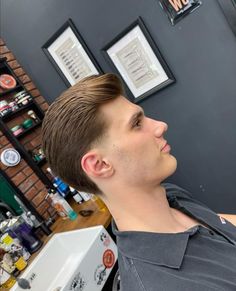 a young man getting his hair cut in a barbershop at a local salon