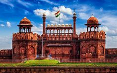 a large building with two towers and a flag flying in the sky above it that says red fort a hindu palace?