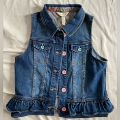 a denim vest with ruffles and buttons on it